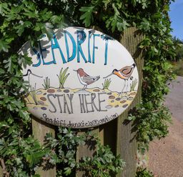 A sign with the text Seadrift Stay Here and illustrations of birds at Seadrift Dunwich Near Westleton