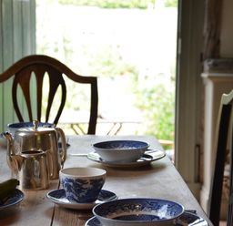 A dining table with blue and white china cups bowls plates a silver teapot and pears at The Gig House Stowupland