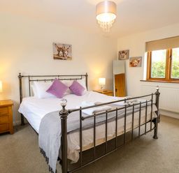 A bedroom with a bed and bedside table at The Mulberry, nr Bungay