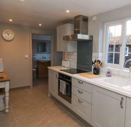 A kitchen with appliances a sink and a wooden table with a toaster at 2 Greensleeves Benhall Near Friston