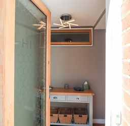 An entryway with a table and baskets at The Hive, Southwold