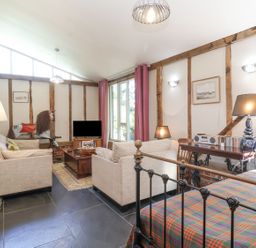 A living room with a TV and sofa at Yew Tree Farm Barn and Stable in Framlingham