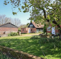 An outdoor view of buildings and trees at The Cart House in Sudbourne Near Orford