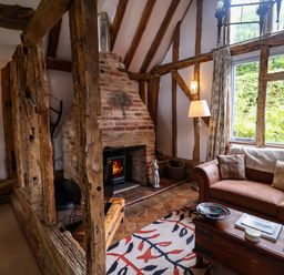 A living room with a fireplace and sofa at Wassicks Cottage, Haughley