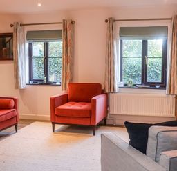 A living room with chairs and a television at Pine Cottage in Woodbridge