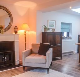 A living room with a fireplace and seating at Pine Cottage in Woodbridge
