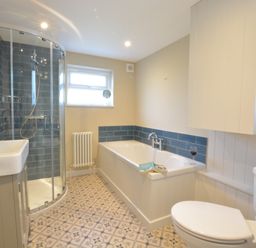 A bathroom with a corner shower, bathtub, sink, toilet, and tiled floor at Somewhere Only We Know in Aldeburgh