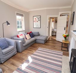 A living room with a sofa and armchair at The Round House in Easton near Framlingham