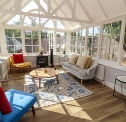 A conservatory with seating and a coffee table at The Round House in Easton near Framlingham