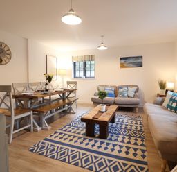 A living room with a dining area and a coffee table at Corner Cottage, Thorpeness