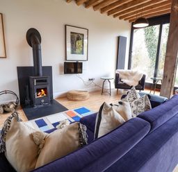 A living room with a wood stove and television at Fishpond House, Sotherton Halesworth