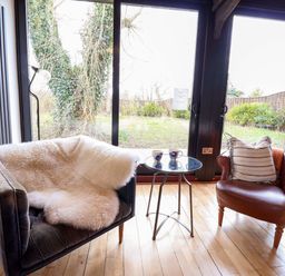 A living room with a chair and table at Fishpond House, Sotherton
