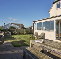 A garden with a table and chairs at Harbour Lights in Southwold