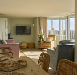 A living room with a sofa and television at Harbour Lights in Southwold