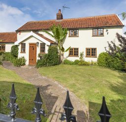 A front view of a house with tiled roof a wooden door a brick path and a lawn at Skelder Parham Parham Near Framlingham