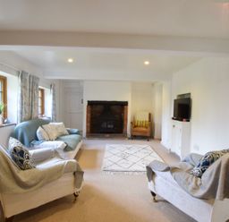 A living room with sofas chairs fireplace rug and television at Skelder Parham in Parham Near Framlingham
