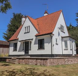 A house with a red roof and garden at High Ground, Reydon