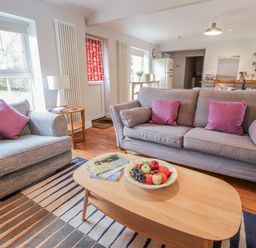 A living room with a sofa and armchair at Fig Cottage, Pettistree Near Woodbridge