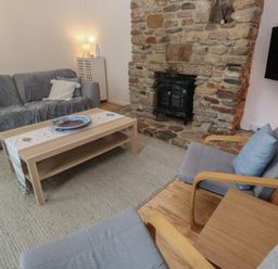 A living room with a fireplace and seating at Candle Croft near Tolgus Mount