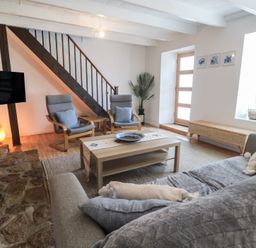A living room with a sofa, chairs, and coffee table at Candle Croft in Tolgus Mount near Redruth