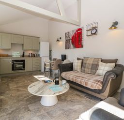 A living room with kitchen area and seating at Bottom Lodge in Penhow