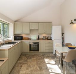A kitchen with cabinets and appliances at Bottom Lodge in Penhow