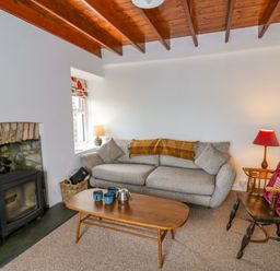 A living room with a sofa, table, and fireplace at Ceunant near Newport