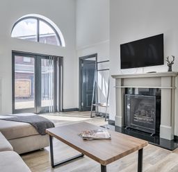 A living room with a coffee table and television at The Annex in Wimborne Minster