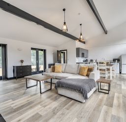 A living room with a sofa and dining area at The Annex in Wimborne Minster