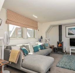 A living room with a sofa and television at The Lookout in Polzeath