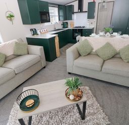 A living room with sofas and a coffee table at Oyster Lodge in Little Haven