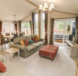 A living room with sofas dining table and chairs and a television at Coniston View 9 Dock Acres near Tewitfield