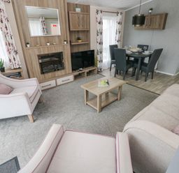 A living room with armchairs sofa coffee table and dining table at Starfish Retreat in Little Haven near Broad Haven