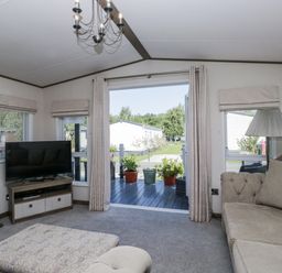 A living room with a television and sofa at Lilac Lodge in Carnforth