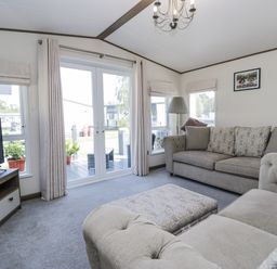 A living room featuring a sofa and television at Lilac Lodge in Carnforth