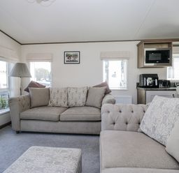 A living room with a sofa and a microwave at Lilac Lodge in Carnforth
