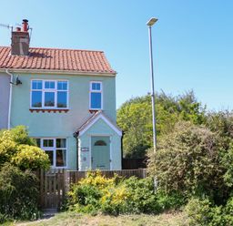 A two-story end terrace house with a front garden and a street lamp at Beck View in Sheringham