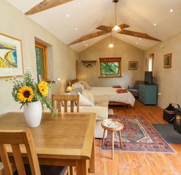 A studio with a bed and dining table at Brambly Cabin in Crediton