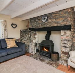 A living room with a fireplace and sofa at Wayside near Kingsbridge