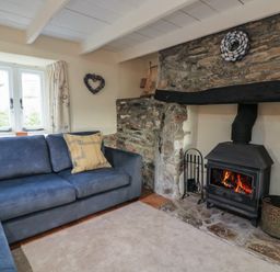 A living room with a fireplace and sofa at Wayside near Kingsbridge