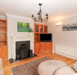 A living room with wooden cabinets fireplace television and seating at Hazelwood in Leap County Cork
