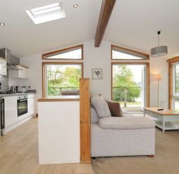 A living room and kitchen area with a sofa and kitchen units at 3 Southern Place in Dobwalls