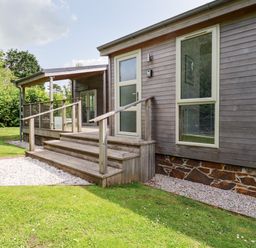 A wooden exterior of a house with stairs leading to a door and a covered porch at 6 Southern Place in Dobwalls
