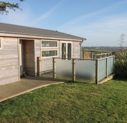 A wooden house with a small porch and frosted glass railing on a grassy lawn at 12 Faraway Fields in Dobwalls