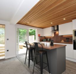 A kitchen with bar stools and appliances at 24 Meadow Retreat in Dobwalls