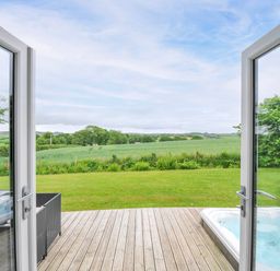An outdoor area with a wooden deck and hot tub at 1 Horizon View in Dobwalls