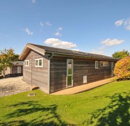 A wooden house with windows and door surrounded by grass at 3 Horizon View Dobwalls