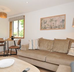 A living room with a sofa and dining area at 12 Meadow Retreat in Dobwalls