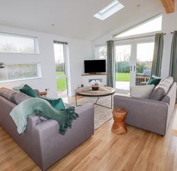 A living room with two sofas a round wooden table a floor lamp and a television at 14 Horizon View in Dobwalls