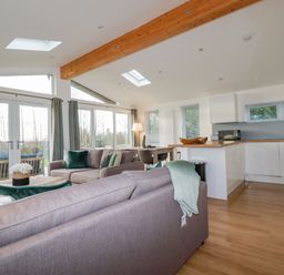 An open-plan living area with sofas, dining table, kitchen units, and large windows at 14 Horizon View in Dobwalls